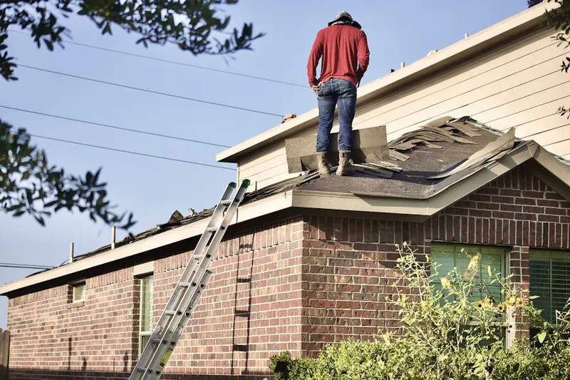 Professional roofer working on a residential roof in Scobeyville